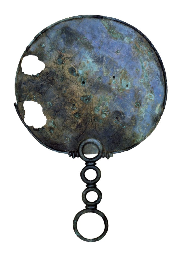 Photo of Portesham mirror showing the swirly decorative Celtic art and ornate handle.