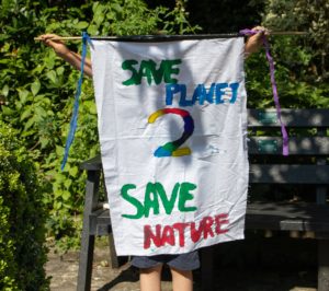 Child holding Save the Planet poster