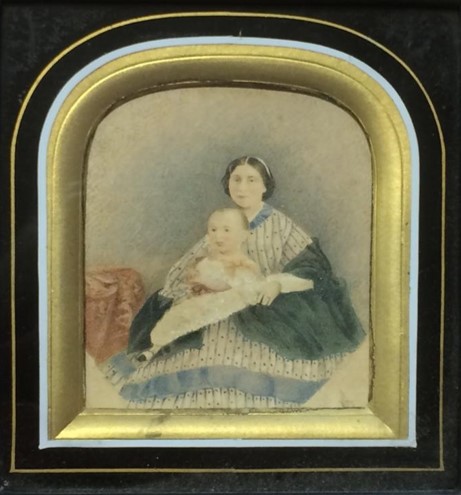 A portrait featuring Hardy as a child and his mother sitting while holding him.