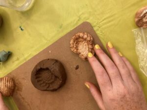 A hand is shown next to a fossil and a fossil casting