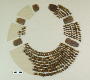Lots of amber beads laid out in the shape of the necklace they were once part of.